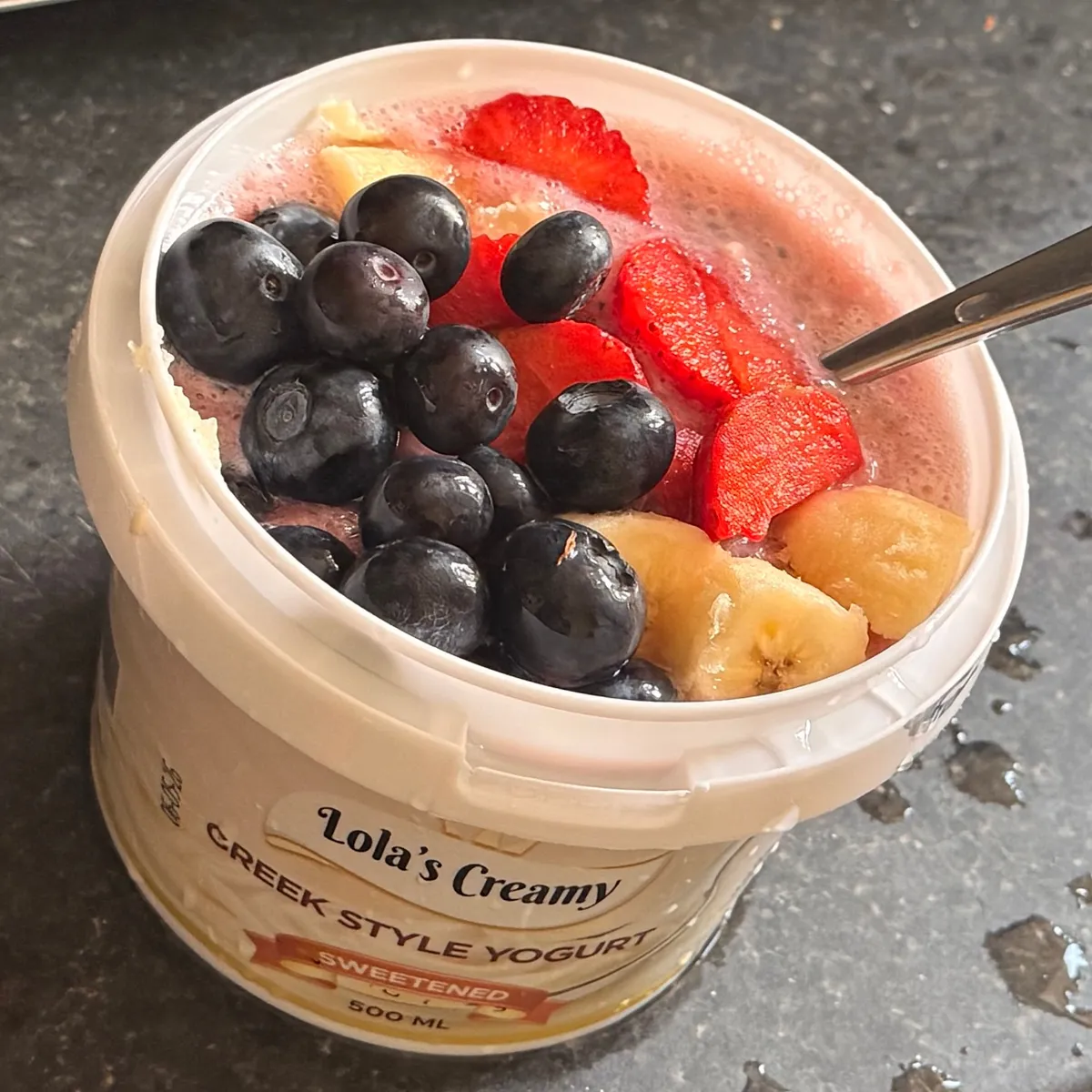 Lola's Creamy sweetened yogurt topped with strawberries, blueberries and banana